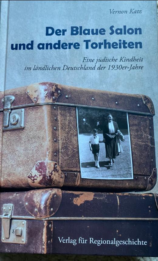 Buchcover "Der Blaue Salon und andere Torheiten", Abbildung von zwei alten Koffern. An einem hängt eine schwarz-weiße Fotografie, die eine Frau und ein Kind zeigt
